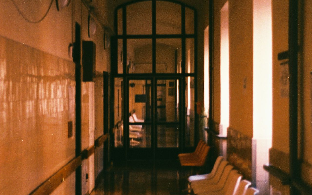 An empty hospital hallway with rows of chairs
