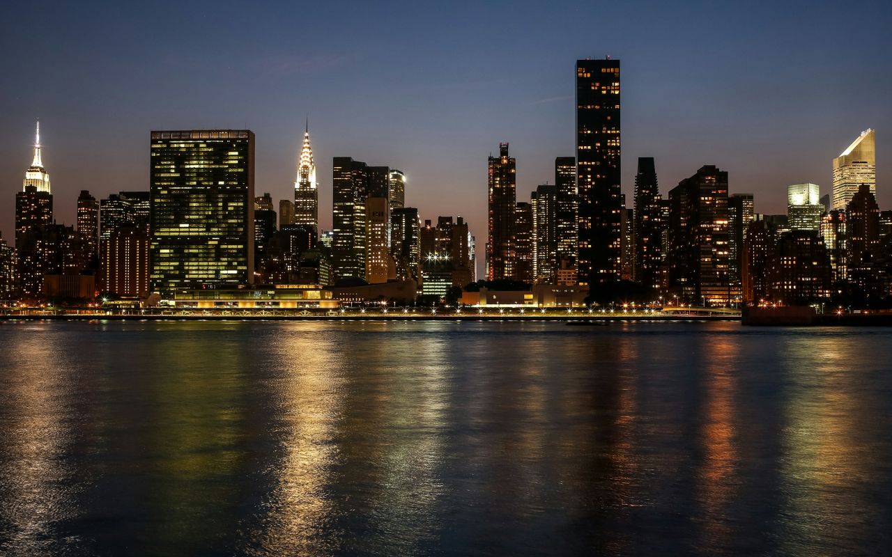 A city skyline across the water at night