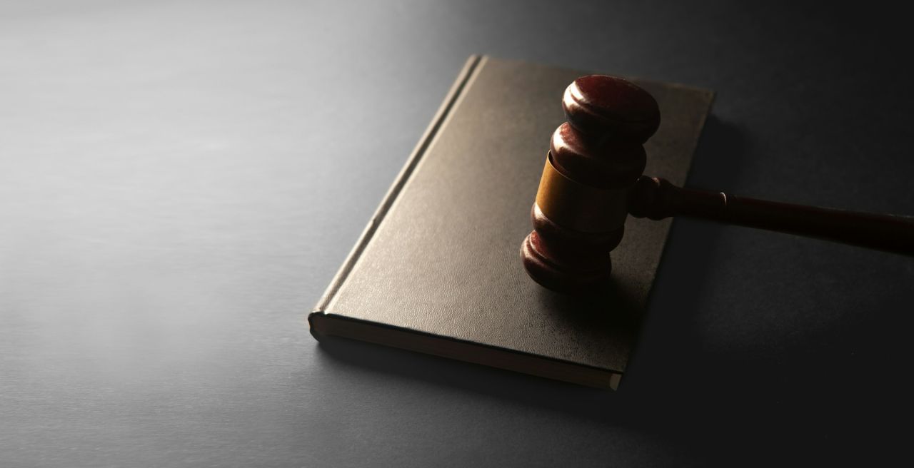 A wooden gavel resting on a closed book